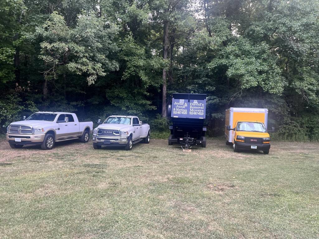 Our fleet: pickup trucks, the lettered dump trailer, and the yellow box truck